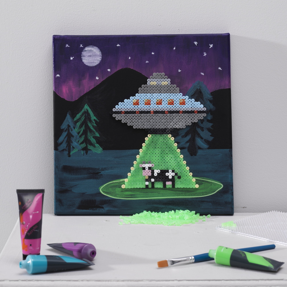 Lag et mixed media-bilde med rørperler og akrylmaling